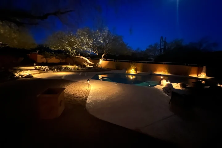 Decorative landscape lights illuminating backyard pool area in Tucson AZ