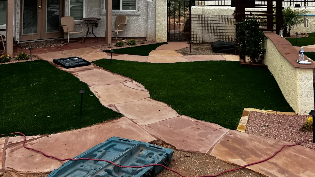 Curved travertine paver pathway and patio installation weaving through a backyard landscape.